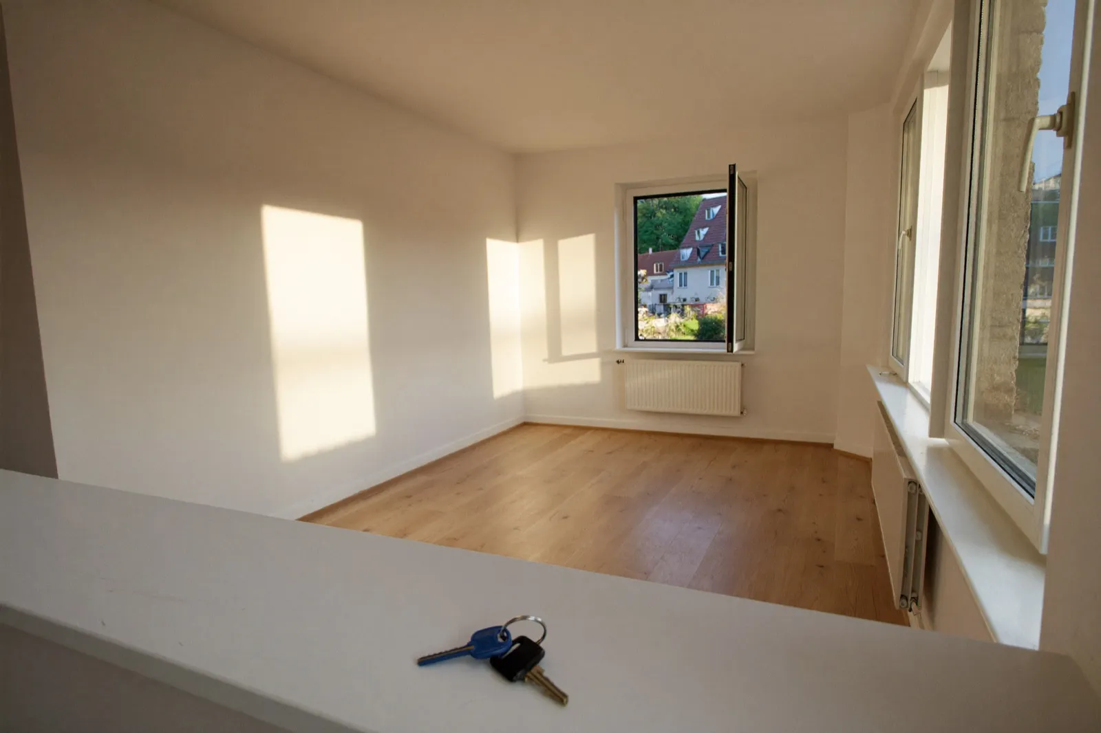Wohnungsschlüssel liegen bereit in einer leeren, frisch renovierten Mietwohnung.